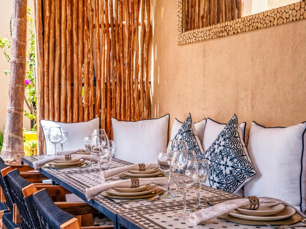 - une table avec des verres à vin et des assiettes dans l'établissement Riad Ines Home, à Marrakech
