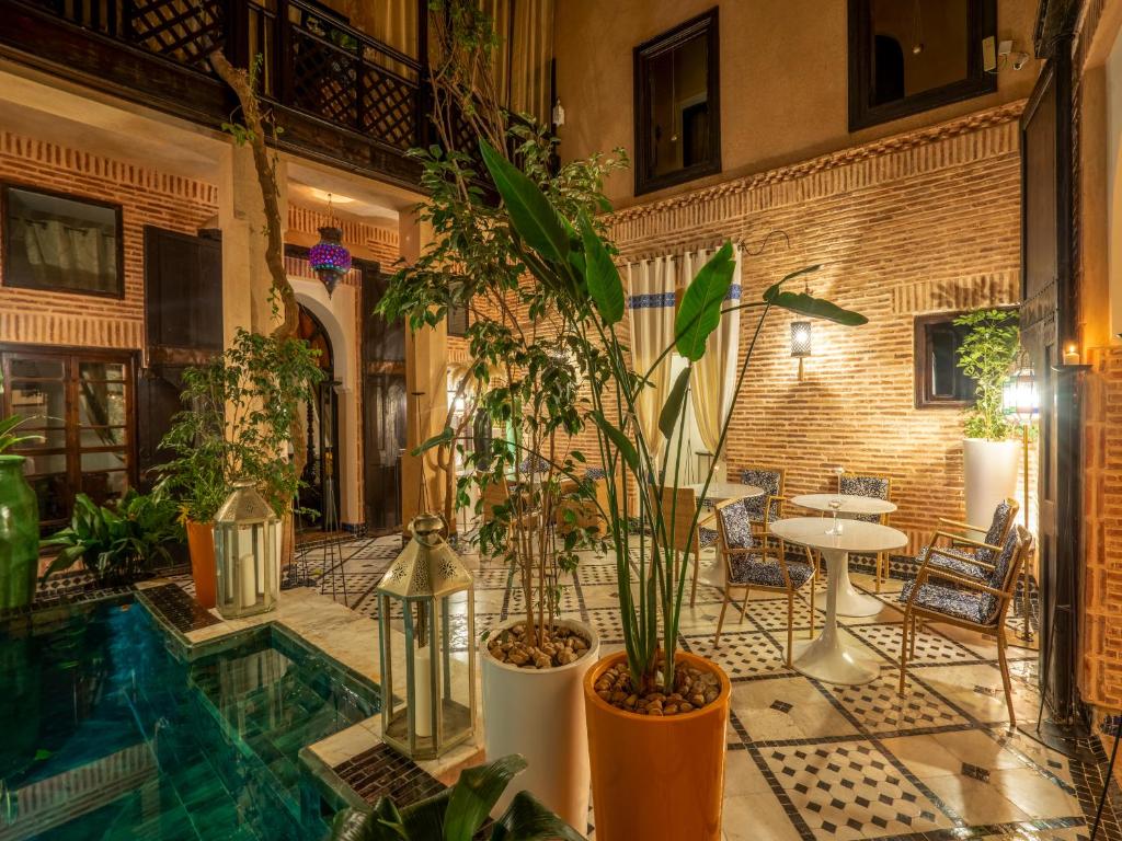 une salle remplie de nombreuses plantes et une piscine dans l'établissement Riad Ines Home, à Marrakech