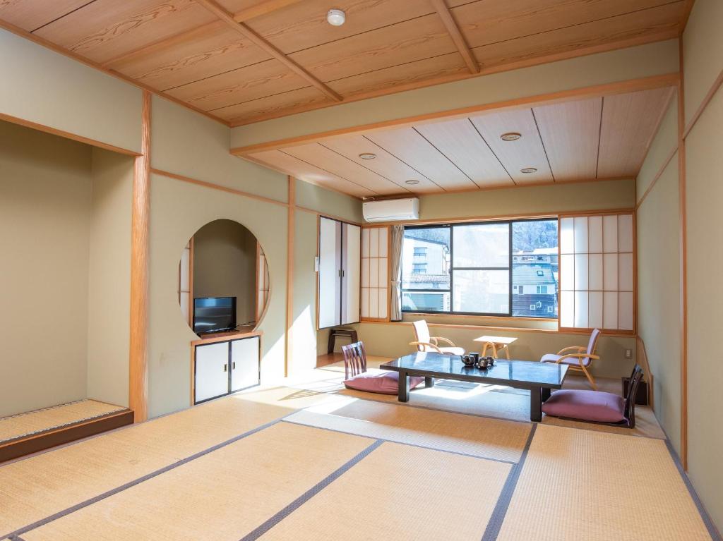 un salon avec une table et des chaises dans l'établissement Tabist Kazeyuki, à Takayama