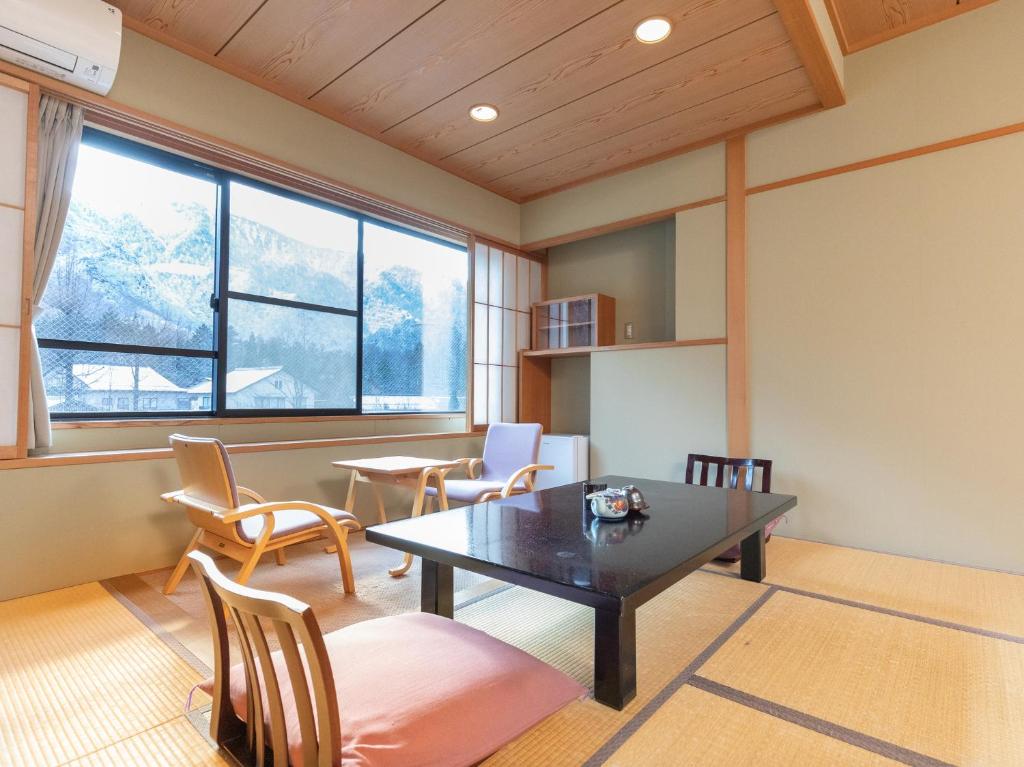 un salon avec une table et des chaises dans l'établissement Tabist Kazeyuki, à Takayama