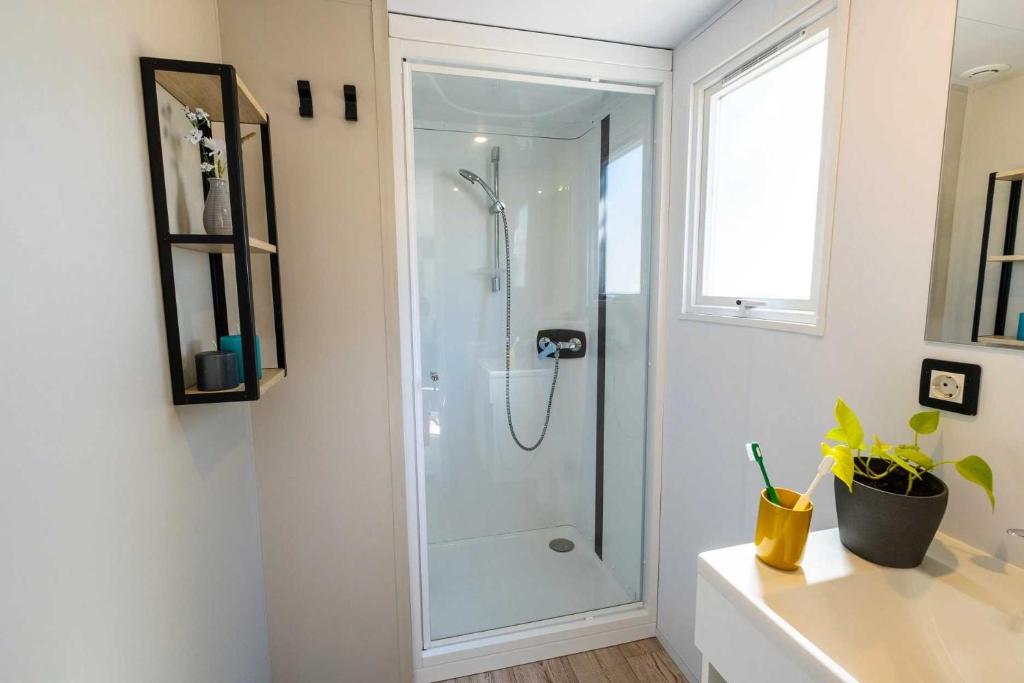 une salle de bain avec une douche avec une porte vitrée dans l'établissement Camping 4 étoiles - Parc aquatique - ef0bdc, à Martigues 19 autres photos