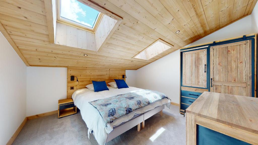 une chambre avec un lit et un plafond en bois dans l'établissement Résidence Hôtelière Bellecôte 4 étoiles, à La Plagne Tarentaise