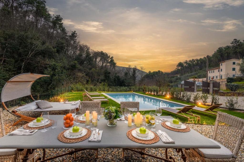 - une table avec de la nourriture et des bougies à côté de la piscine dans l'établissement Molino Giusti Farmhouse, à Santa Maria del Giudice