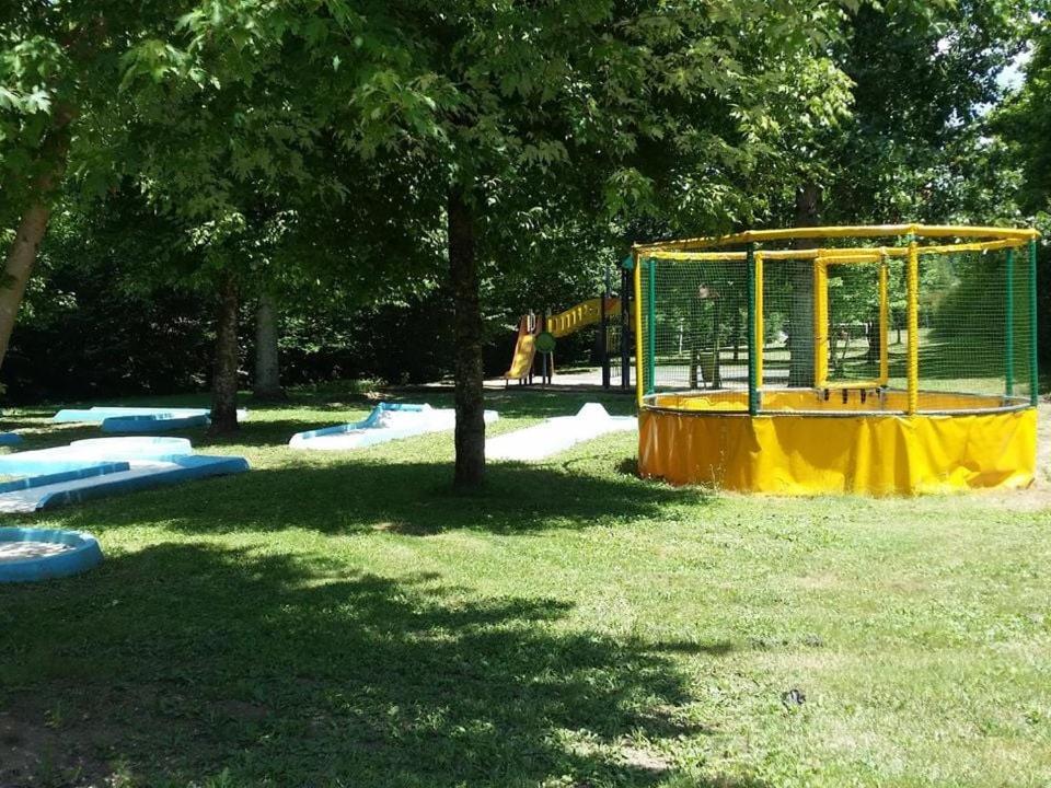 un parc avec une aire de jeux jaune dans l'établissement Camping maeva Escapades Les Bö-Bains, à Badefols-sur-Dordogne
