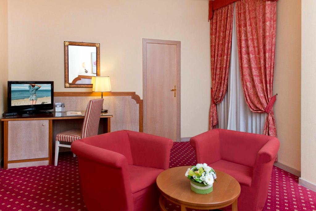 un salon avec deux chaises et une table dans l'établissement Hotel Promenade, à Montesilvano