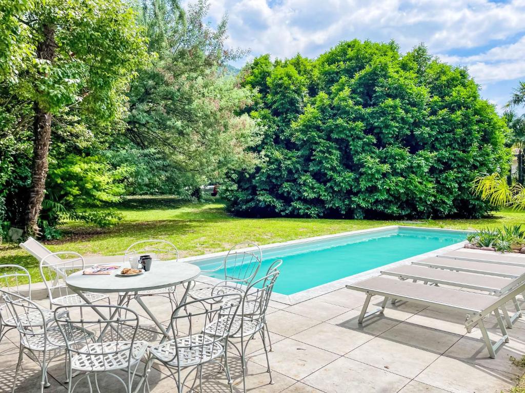 un patio avec une table et des chaises à côté d'une piscine dans l'établissement Villa Eugenia by Interhome, à Dervio