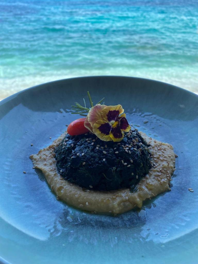 un morceau de pain avec une fleur sur une plaque bleue dans l'établissement Hotel Le Ghiaie, à Portoferraio 50 autres photos