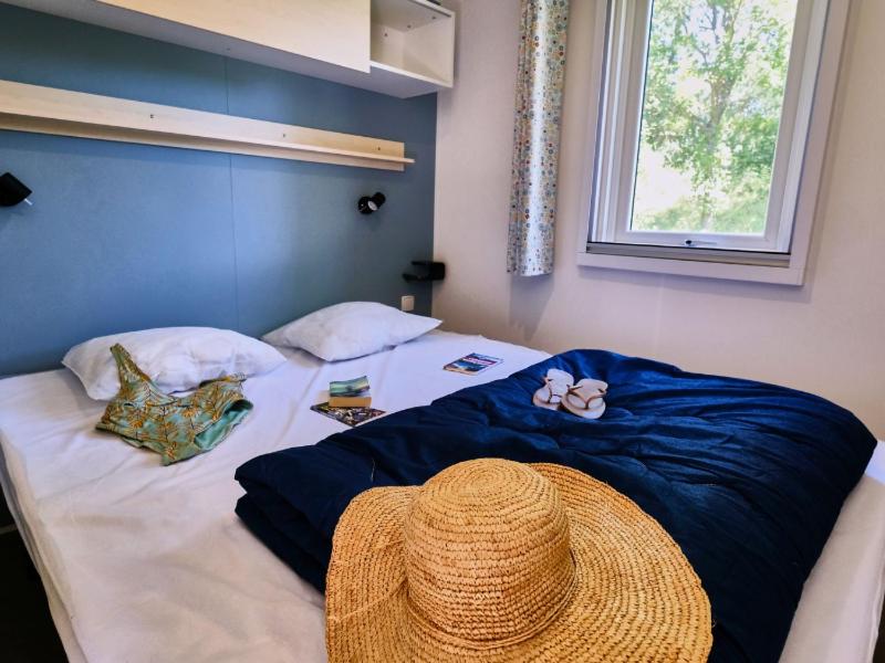 - un lit avec un chapeau de paille au-dessus dans l'établissement Camping le Relais du Léman, à Messery 33 autres photos