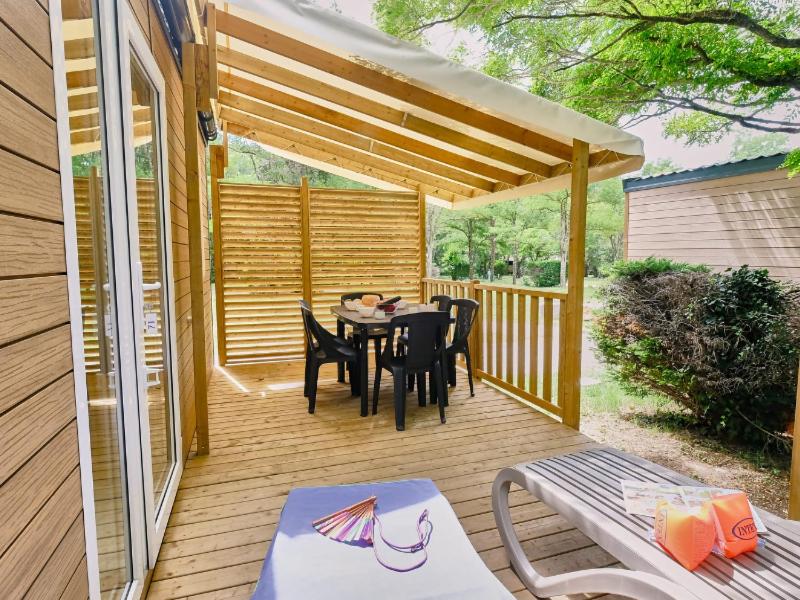 une terrasse en bois avec une table et des chaises dessus dans l'établissement Camping le Relais du Léman, à Messery