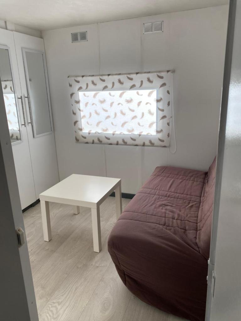une petite chambre avec un lit et une table dans l'établissement Bungalow cosy varois avec piscine soleil calme et nature, à Pourrières 20 autres photos