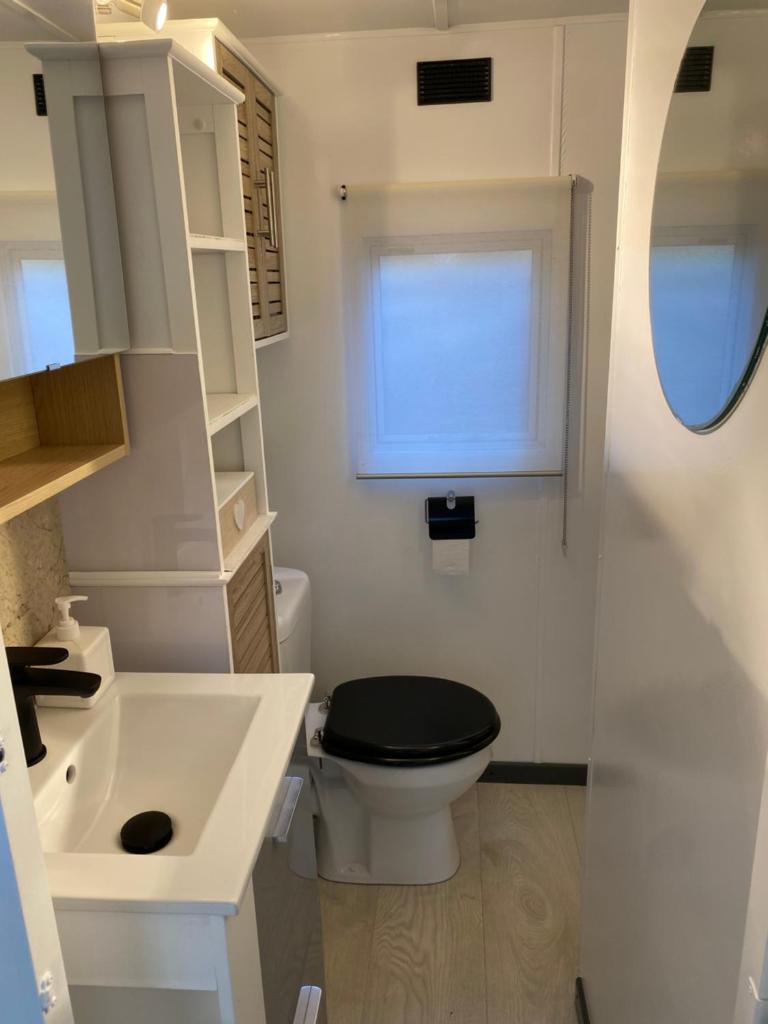 une petite salle de bain avec toilettes et lavabo dans l'établissement Bungalow cosy varois avec piscine soleil calme et nature, à Pourrières
