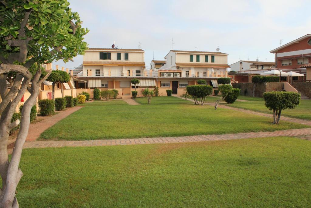Une rangée de maisons dans un parc avec de l'herbe dans l'établissement Hotel Calypso, à Ardea