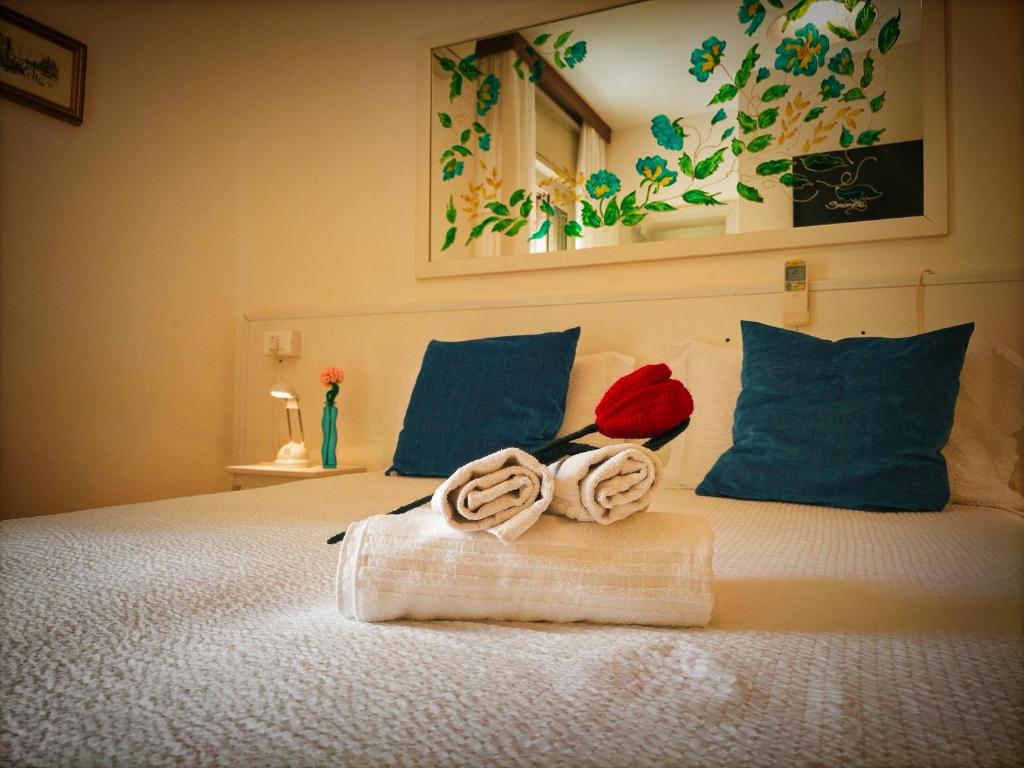 - un lit avec une serviette et une rose dans l'établissement Le Petit Hotel, à Lido di Jesolo