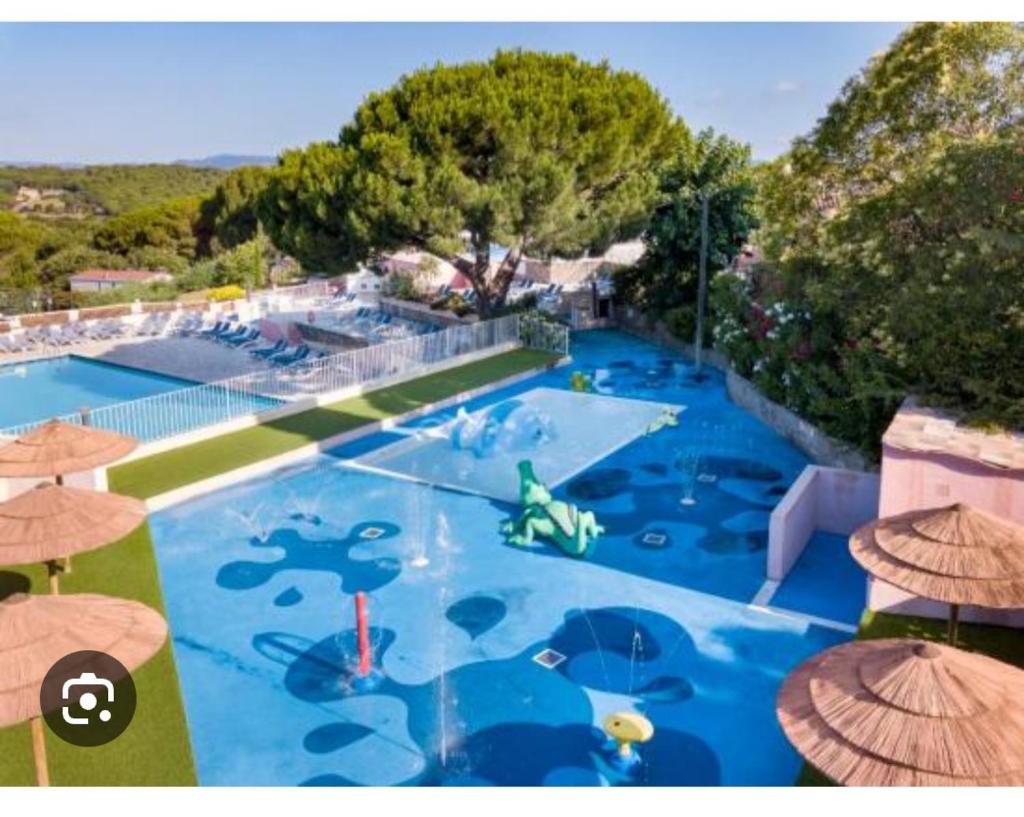 une vue aérienne d'une grande piscine avec des parasols dans l'établissement Mobil home Gassin, à Gassin
