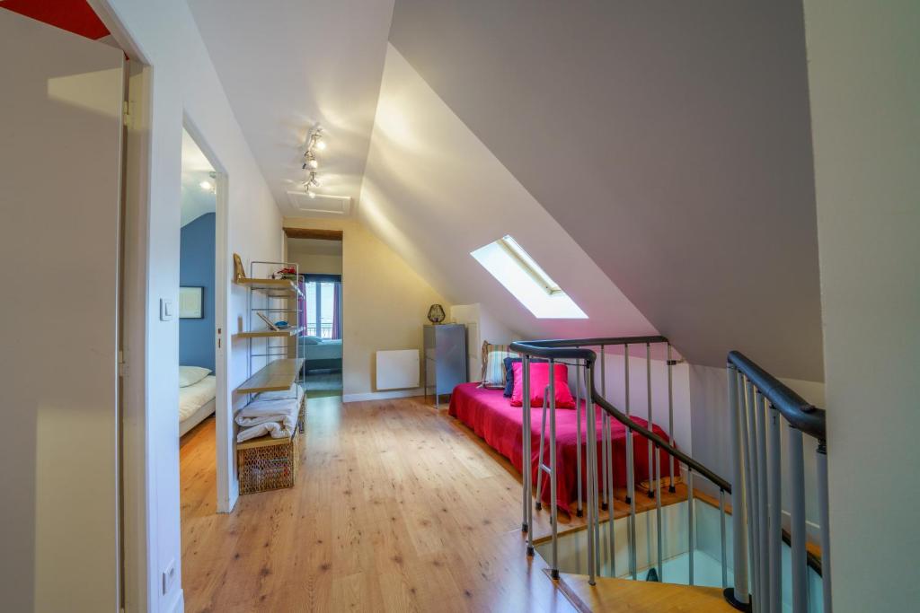 une chambre mansardée avec un canapé rouge et un escalier dans l'établissement Gîte 11 p tout confort Beauval châteaux #piscine, à Chançay 33 autres photos