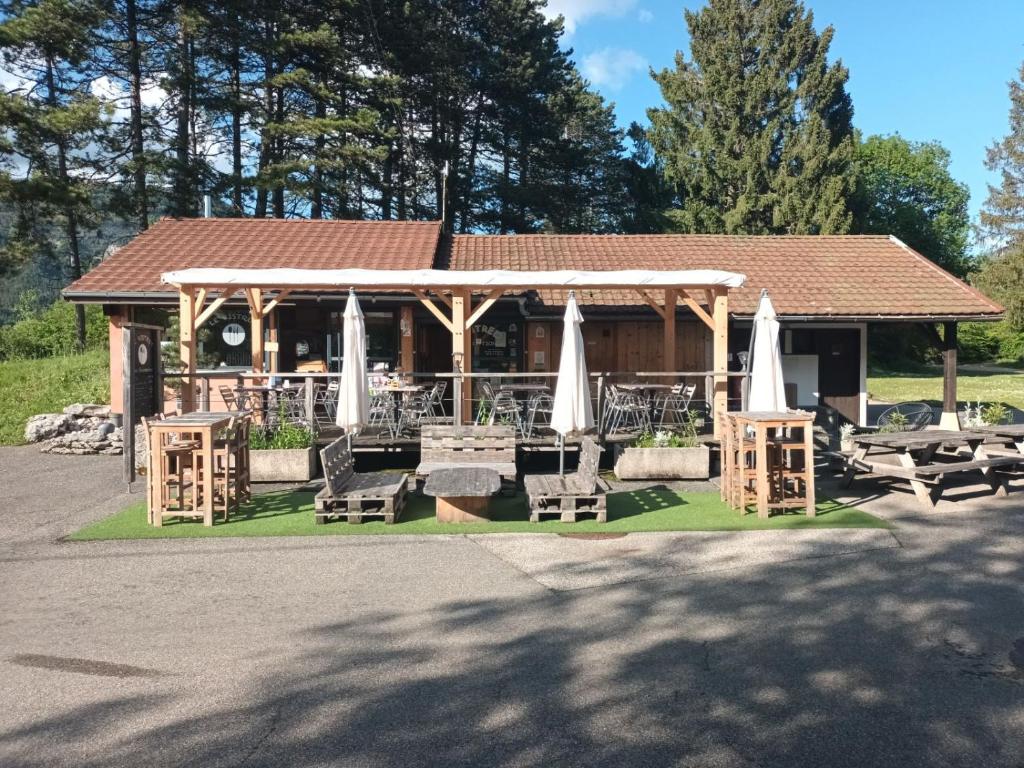 un kiosque avec des chaises et des parasols dans l'établissement Cabane en bois POD 2, à Champfromier