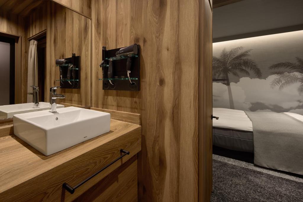 une salle de bain avec un lavabo et un lit dans l'établissement 袖ヶ浦c COAST HIKE HOTEL, à Sodegaura