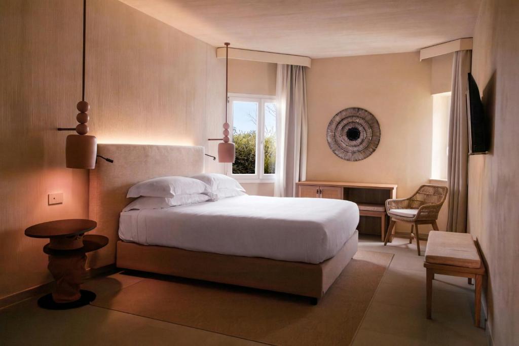 une chambre avec un grand lit blanc et une fenêtre dans l'établissement Mangia's Brucoli, Sicily, Autograph Collection, à Brucoli