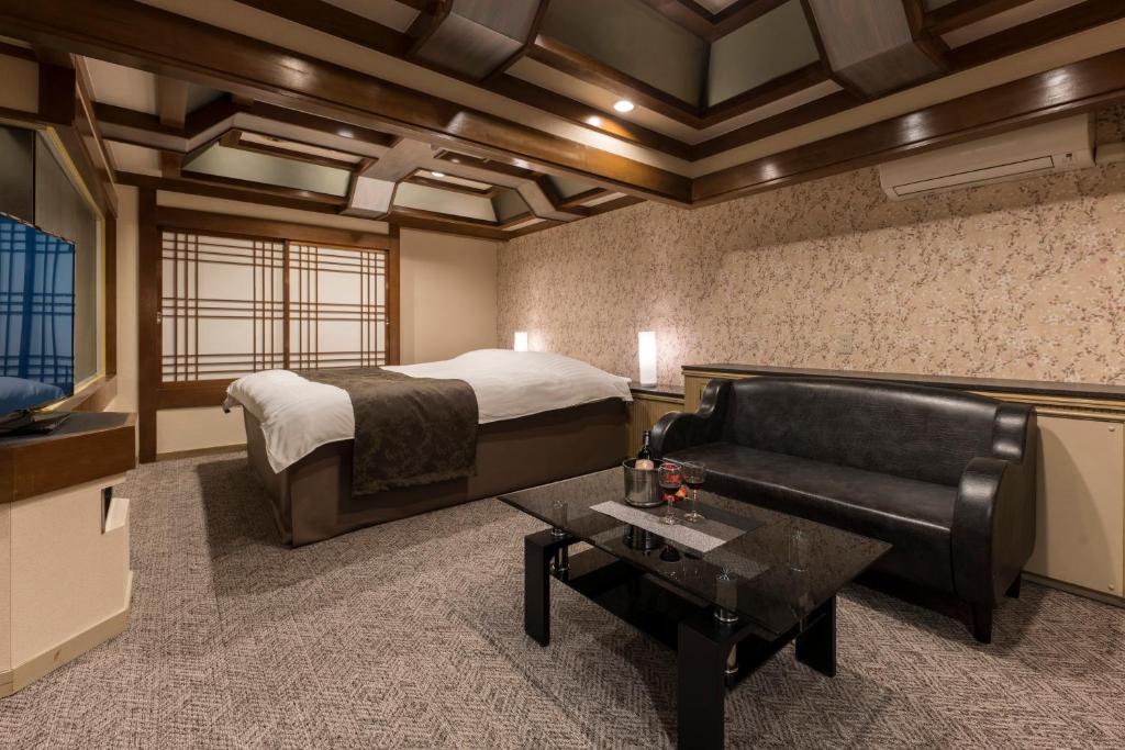 une chambre avec un lit, un canapé et une table dans l'établissement ホテル ジュエリージュエリー 十三, à Osaka