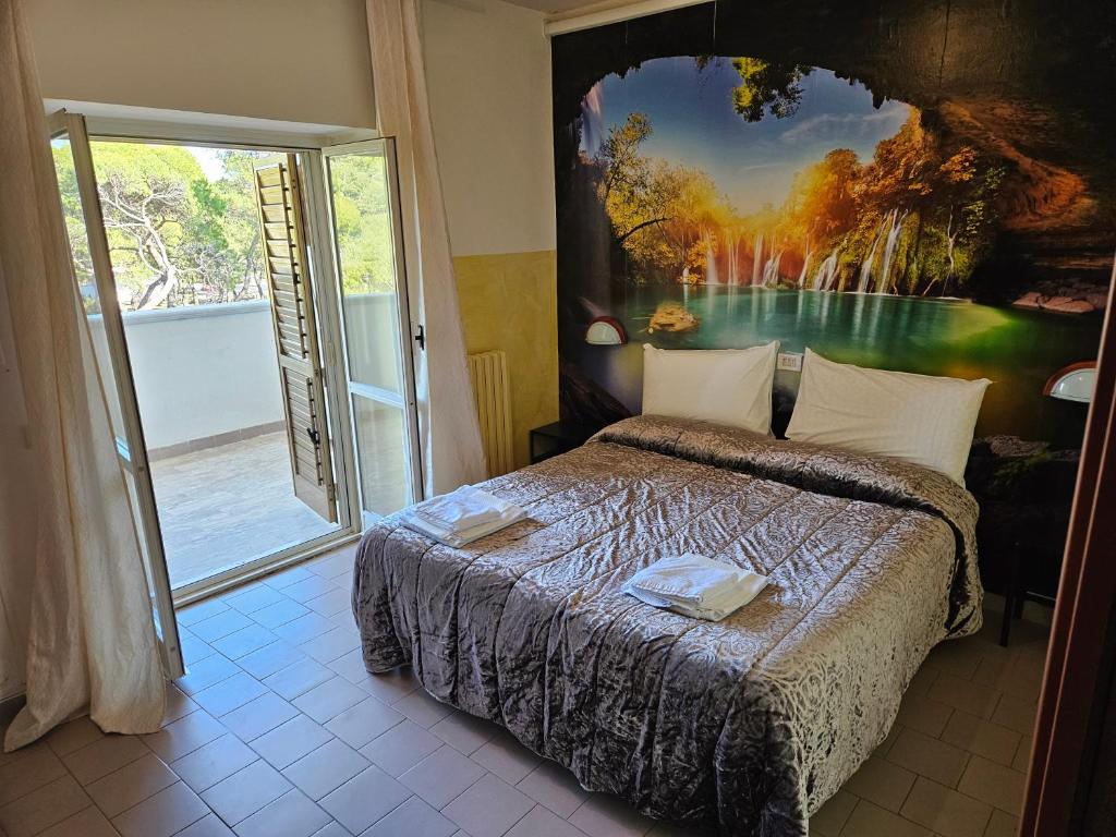 une chambre avec un lit avec un tableau sur le mur dans l'établissement lidodubaihotel, à Marina di Ginosa