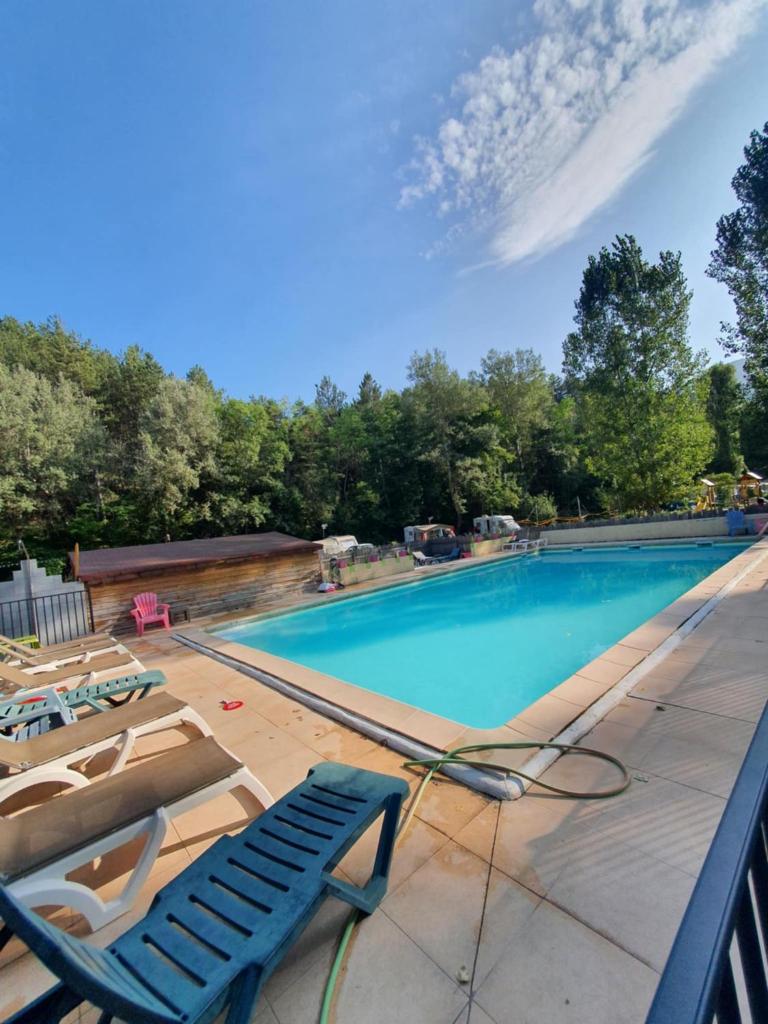 une piscine avec deux chaises longues et une piscine dans l'établissement Mobil home 6 personnes, à Barrême