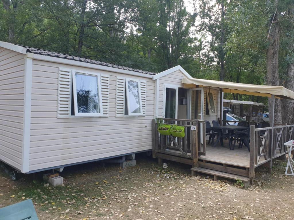 une cabine blanche avec une véranda et une terrasse dans l'établissement Mobil home 6 personnes, à Barrême