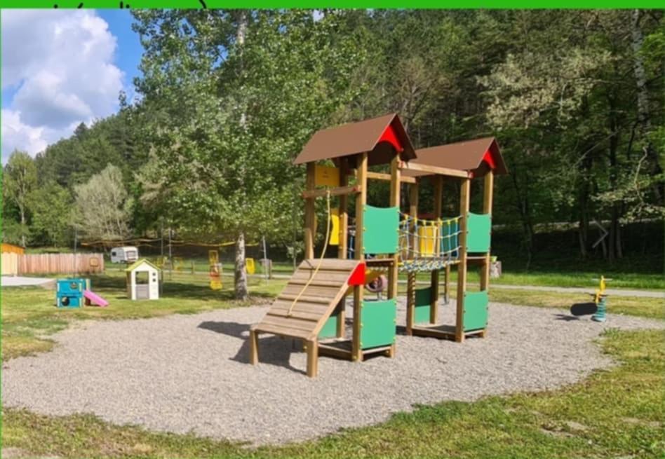 une aire de jeux avec un toboggan et une structure de jeu dans l'établissement Mobil home 6 personnes, à Barrême