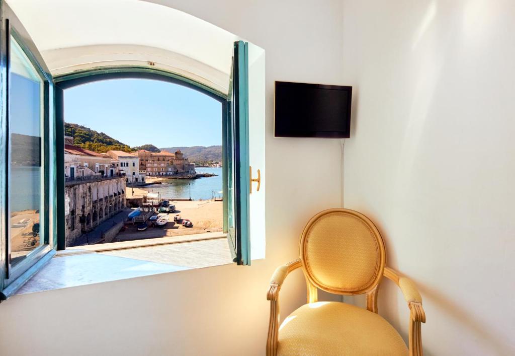 une chaise assise devant une fenêtre avec vue dans l'établissement Hotel Villa Sirio, à Santa Maria di Castellabate