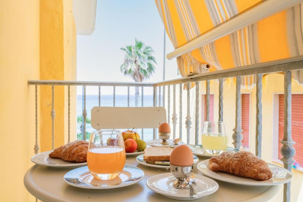 - une table de petit-déjeuner avec des œufs et de la nourriture sur le balcon dans l'établissement Hotel Villa Sirio, à Santa Maria di Castellabate