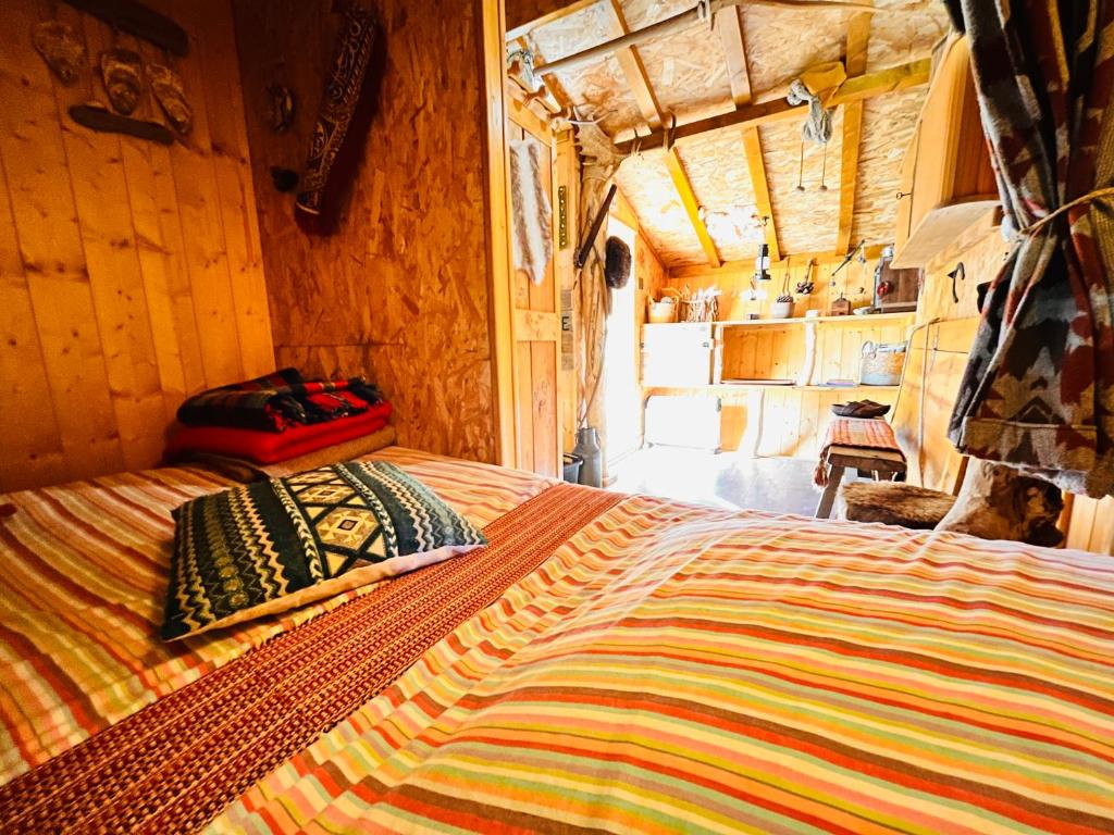 - une chambre avec un grand lit dans une maison dans l'établissement La cabane perchée du trappeur, à Écrainville
