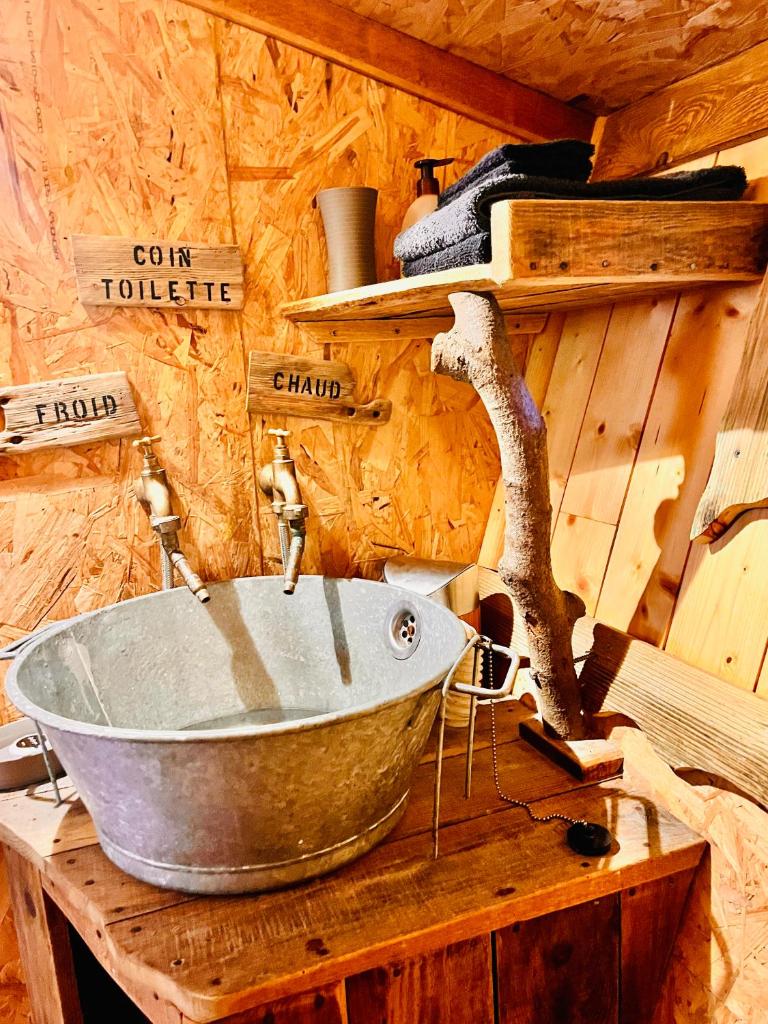 une baignoire en métal assise au-dessus d'une table en bois dans l'établissement La cabane perchée du trappeur, à Écrainville 37 autres photos