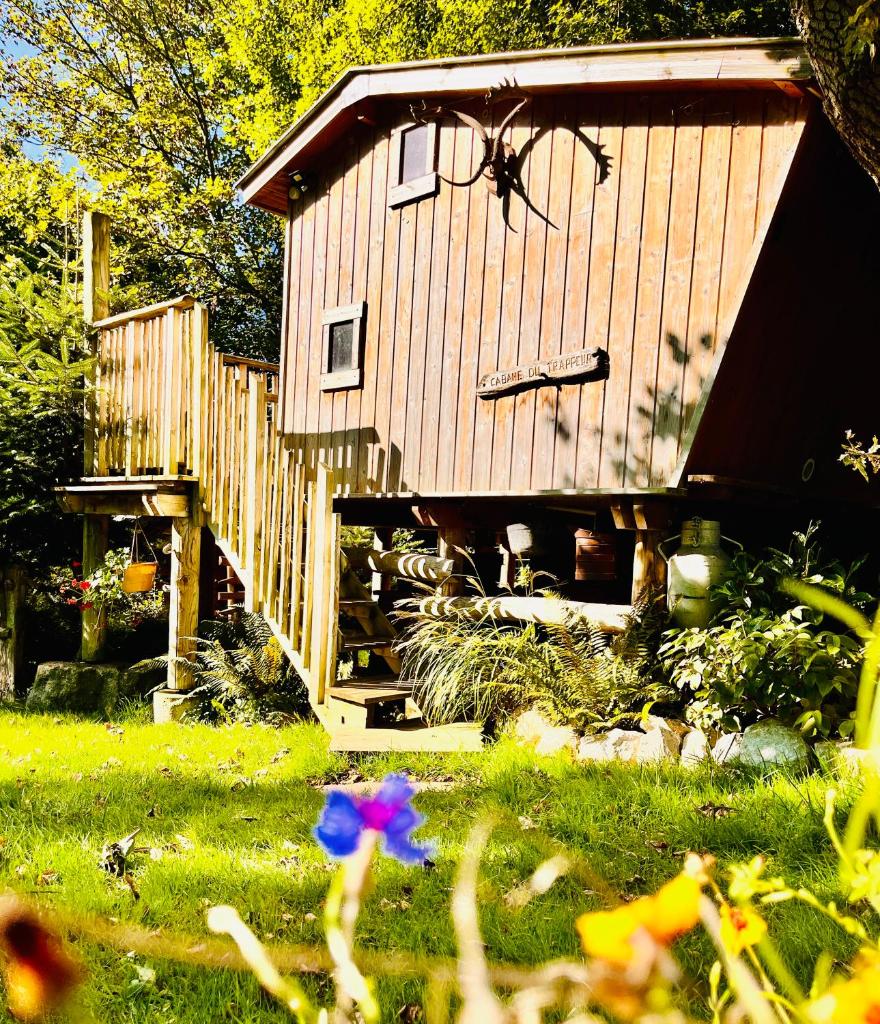 une petite maison avec un escalier en bois dans une cour dans l'établissement La cabane perchée du trappeur, à Écrainville