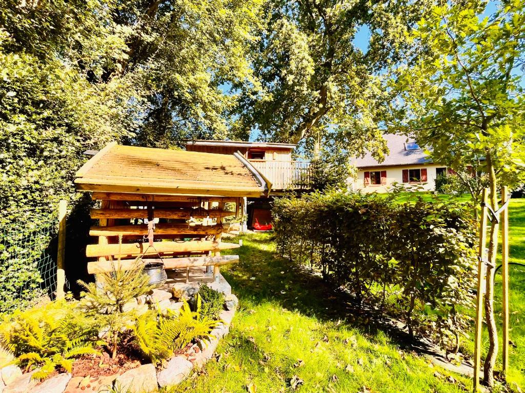 une cabane en rondins dans la cour d'une maison dans l'établissement La cabane perchée du trappeur, à Écrainville