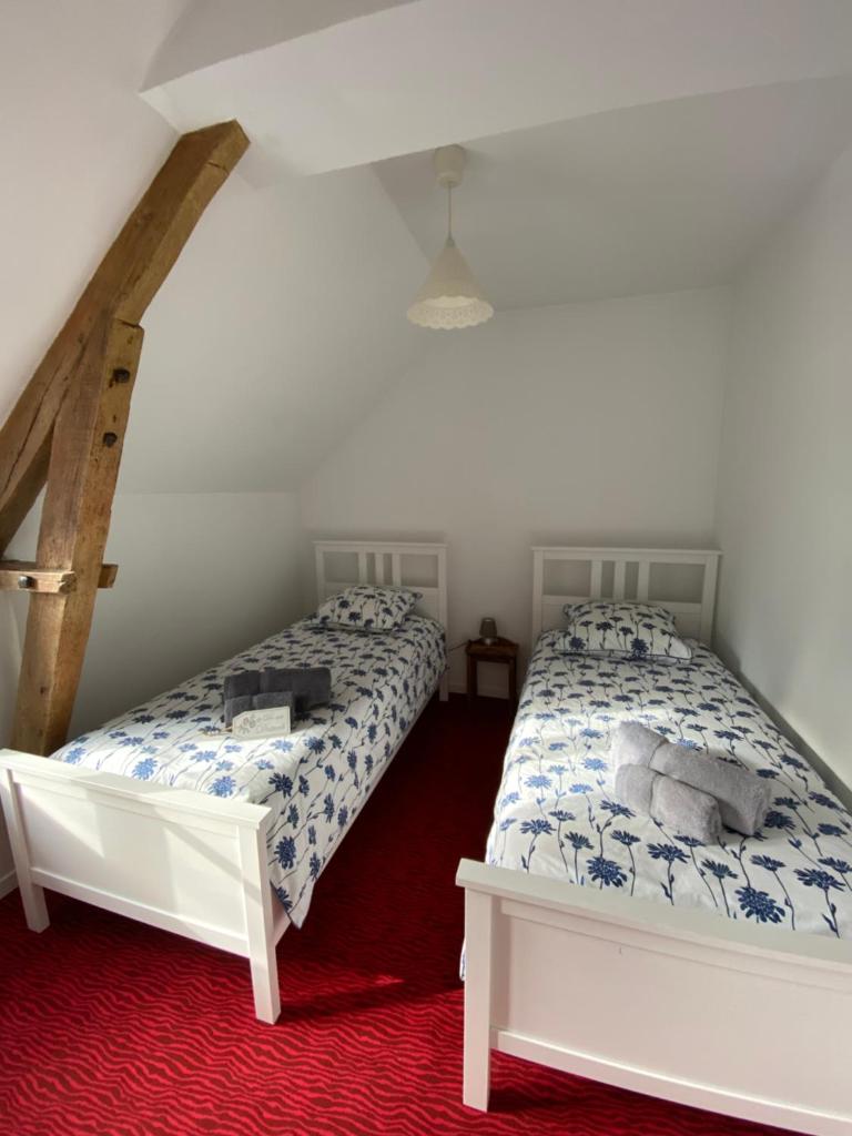 - une chambre avec 2 lits et un tapis rouge dans l'établissement Mill House Gite, à Villaines-la-Juhel