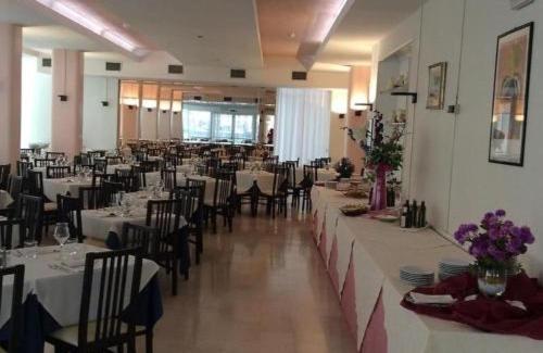 une grande salle de banquet avec des tables et des chaises dans une pièce dans l'établissement Hotel Riviera Nuova Gestione, à Cattolica