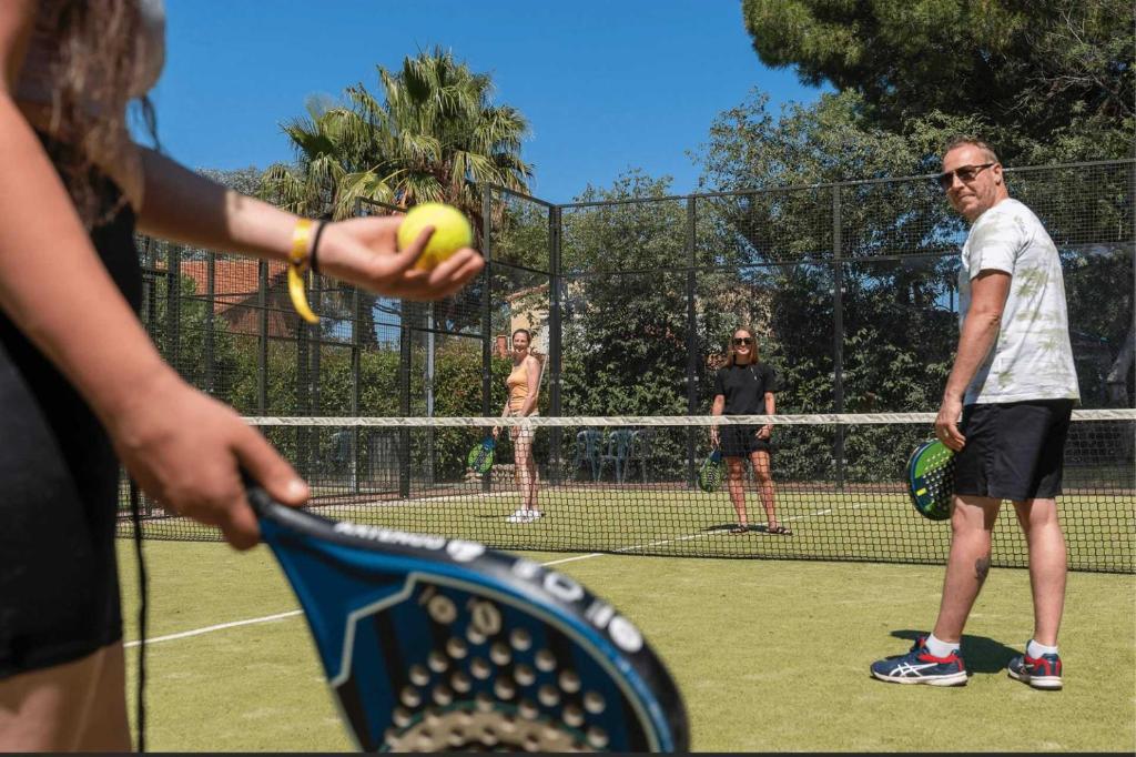 un groupe de personnes jouant au tennis sur un court de tennis dans l'établissement Camping - Piscine - ccai0bg, à Argelès-sur-Mer