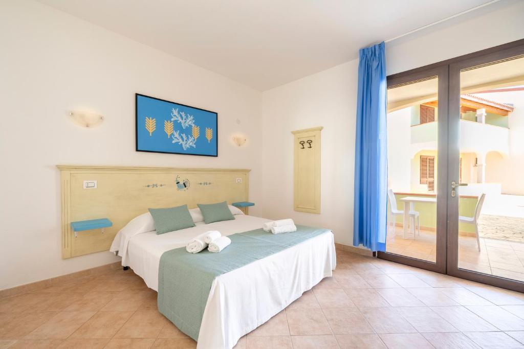 une chambre avec un lit avec des serviettes dessus dans l'établissement Mimose Beach Village, à Badesi 94 autres photos