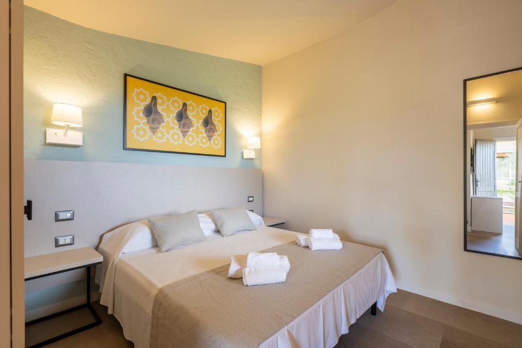 une chambre d'hôtel avec deux lits et un miroir dans l'établissement Mimose Beach Village, à Badesi