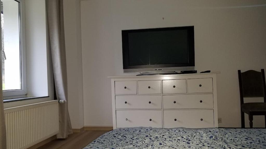 - une télévision au-dessus d'une commode dans la chambre dans l'établissement Au refuge du Bonheur, à Provenchères-sur-Fave