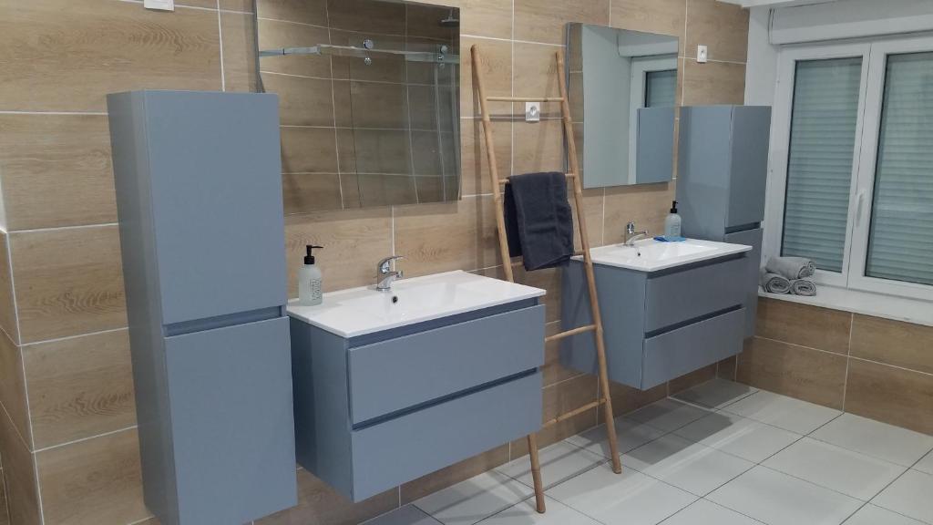 une salle de bain avec deux lavabos et un miroir dans l'établissement Au refuge du Bonheur, à Provenchères-sur-Fave