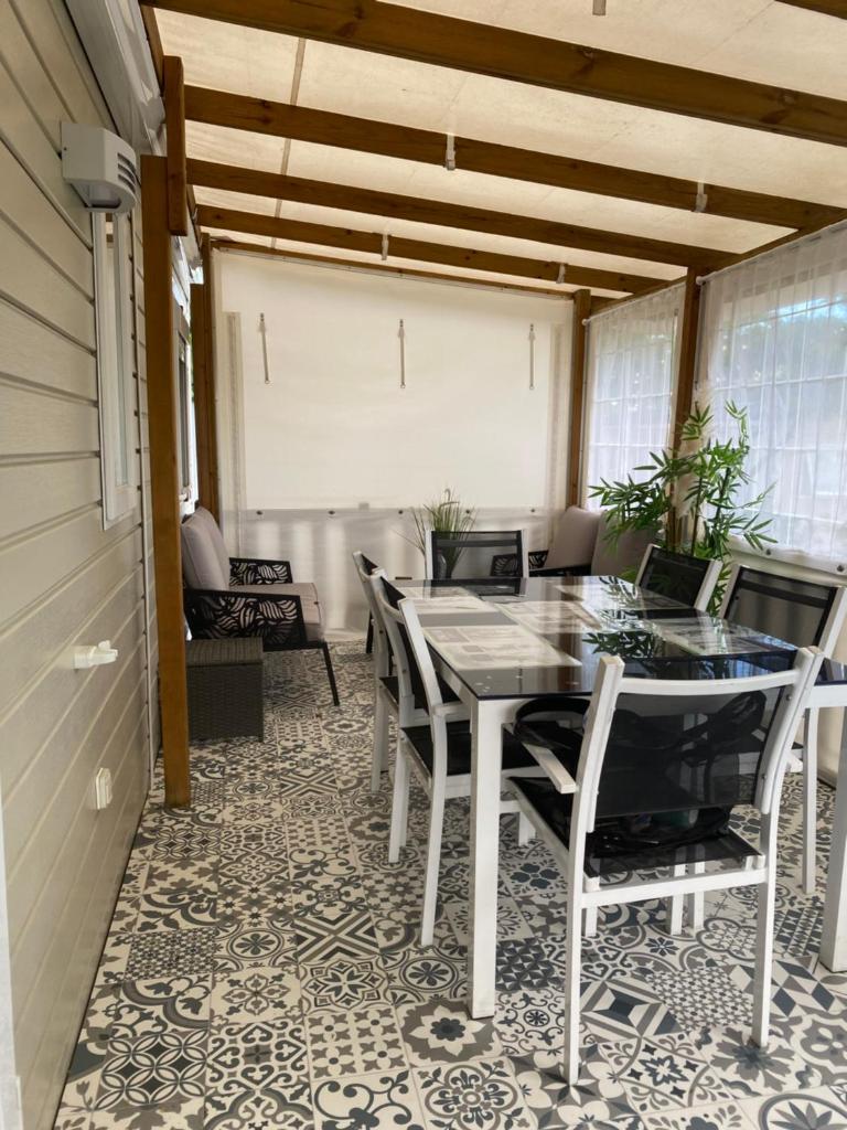 une salle à manger avec une table et des chaises dans l'établissement Mobile Home de Valérie "Les Sables du Midi", à Valras-Plage