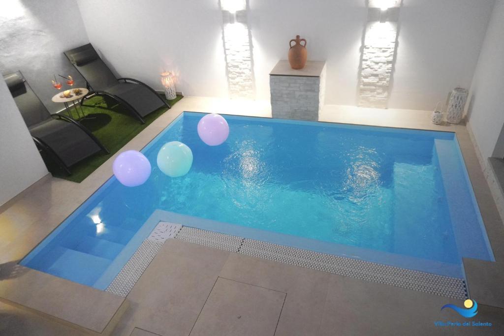 - une grande piscine avec des ballons dans le salon dans l'établissement VILLA PERLA del SALENTO con piscina, à Lido Marini