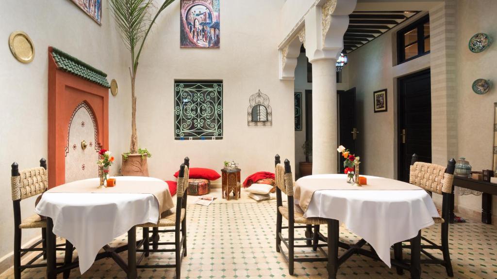 deux tables avec des nappes blanches dans une pièce dans l'établissement Riad Dar Benbrahim, à Marrakech 28 autres photos
