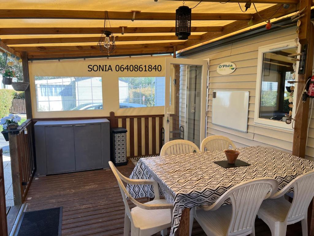 un patio avec une table et des chaises sur une terrasse dans l'établissement chez Sodam by siblu, à Parentis-en-Born