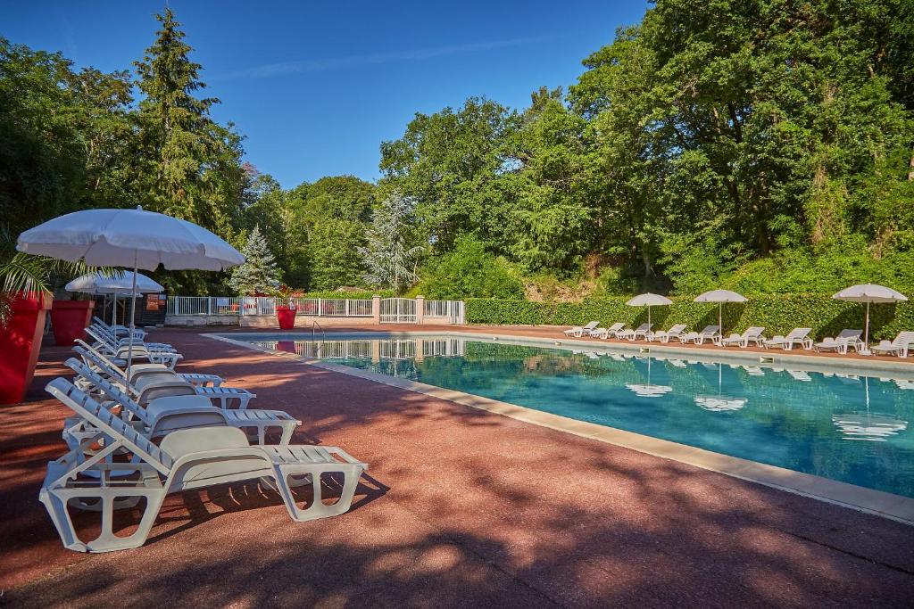 une piscine avec chaises longues et parasols dans l'établissement Camping Parc des Roches, à Saint-Chéron