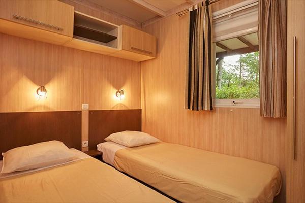 une chambre avec deux lits et une fenêtre dans l'établissement Camping Parc des Roches, à Saint-Chéron