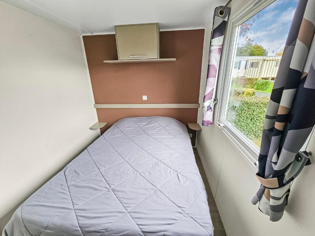 une petite chambre avec un lit et une fenêtre dans l'établissement Loc younes, à Litteau