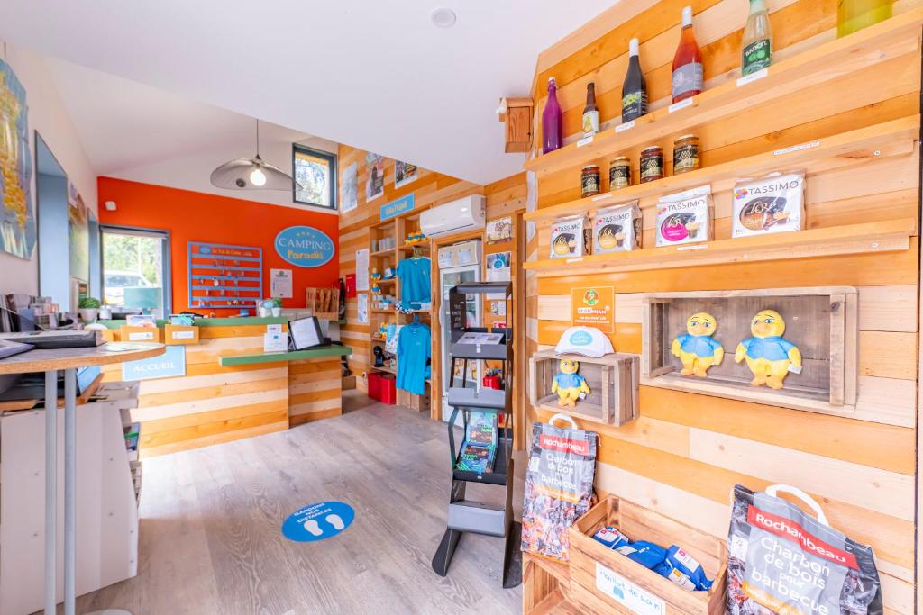 un magasin avec des murs en bois et une étagère avec des jouets dans l'établissement Camping Paradis Val de Coise, à Saint-Galmier