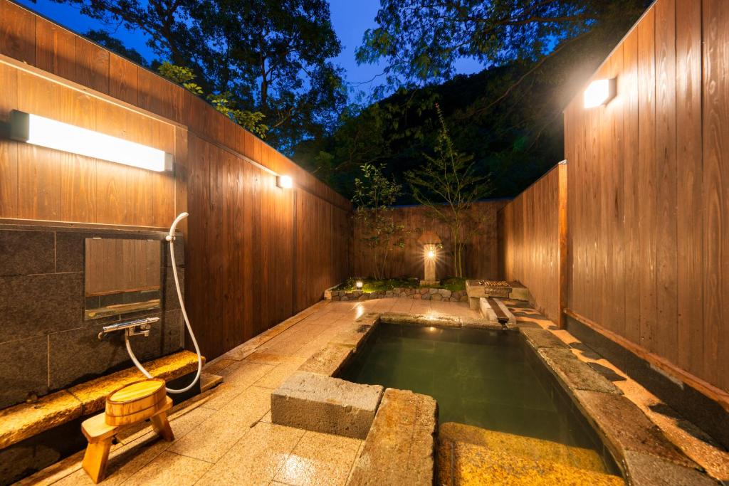 une piscine au milieu d'un mur en bois dans l'établissement Beppu Showaen, à Beppu
