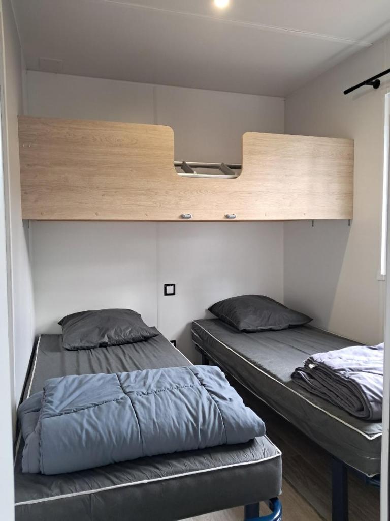 - 2 lits dans une petite chambre avec une étagère dans l'établissement camping les oyats, à Seignosse 37 autres photos